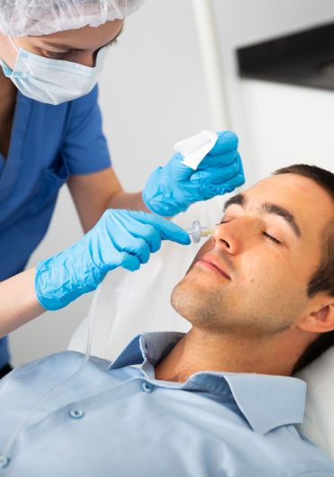 A man is getting a shot in the face.