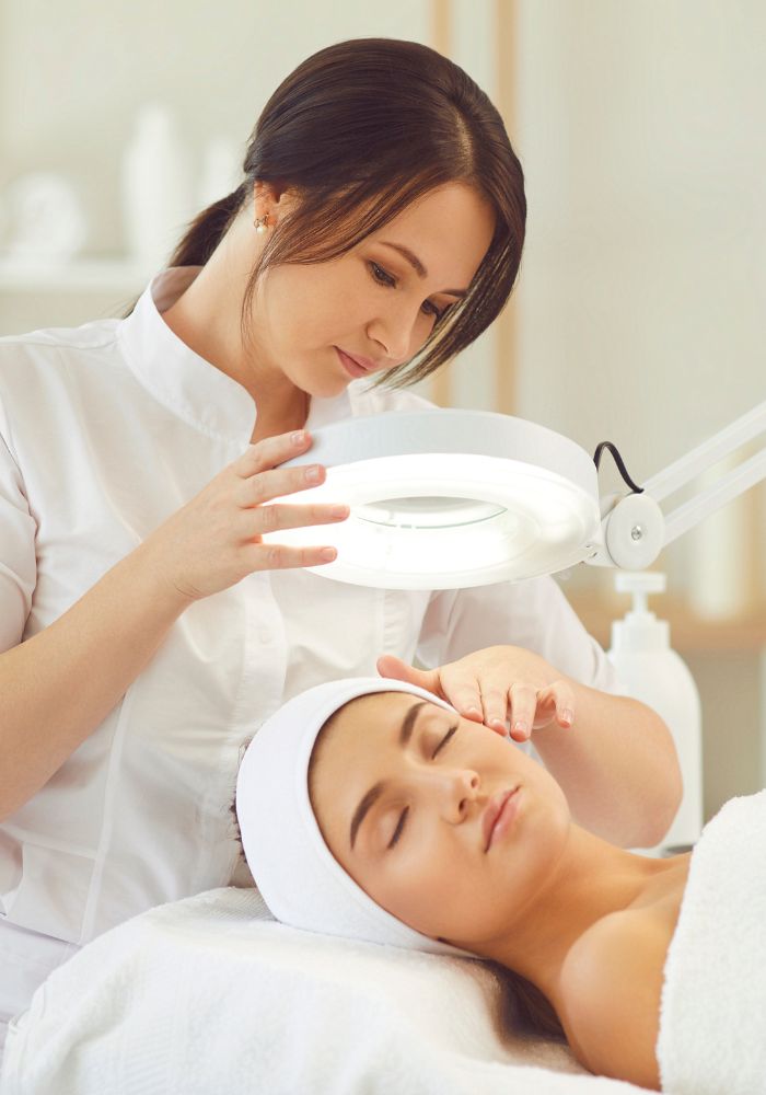 A woman with a white towel on her head getting her hair done.