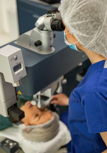 A woman is getting her eyes examined by a nurse.