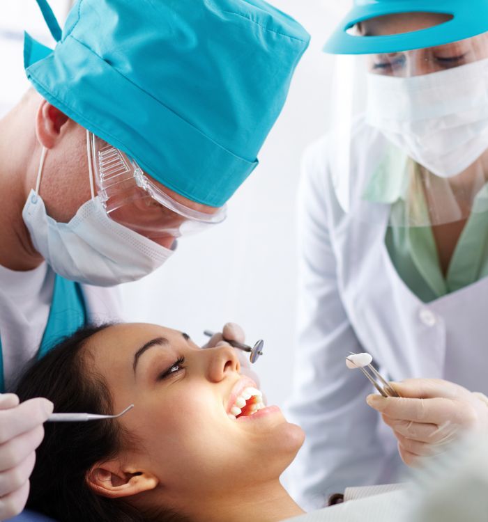 A woman is getting her teeth cleaned by a dentist.