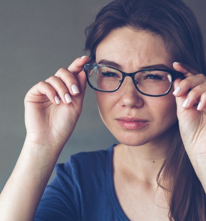 A woman wearing glasses and a blue shirt.