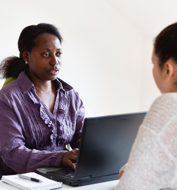 A woman sitting at a desk with a laptop.