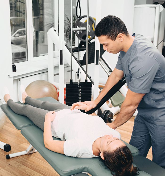 A man massaging a woman on a massage table.