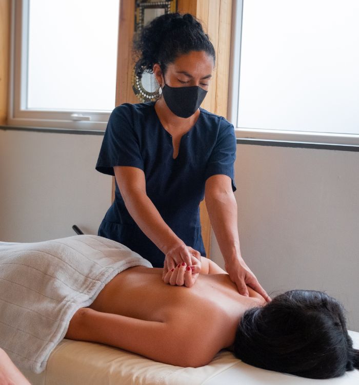 A woman getting a massage with a cloth over her back.