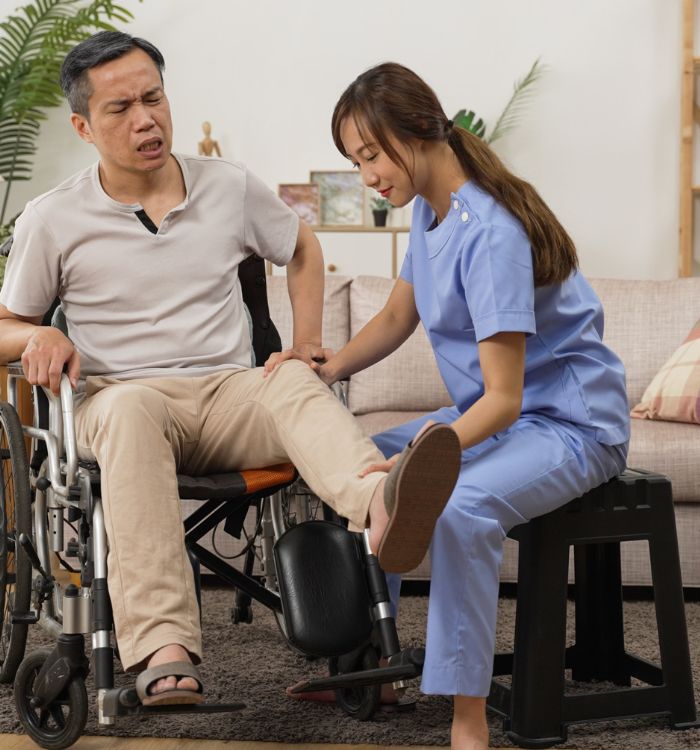 A man in a wheelchair with a woman in a blue shirt and pants.