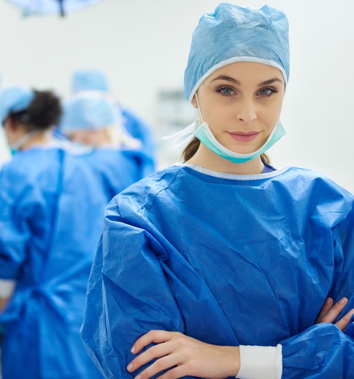 A woman in a blue scrubs uniform posing for a picture.