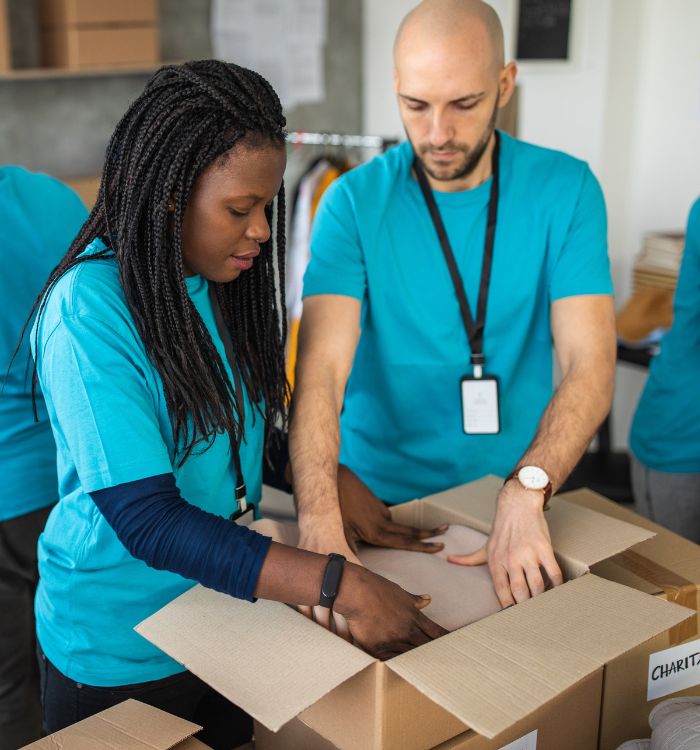 Two people are opening a box and examining its contents.
