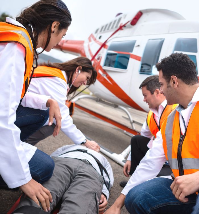 A group of people are working on a man who is laying on the ground.