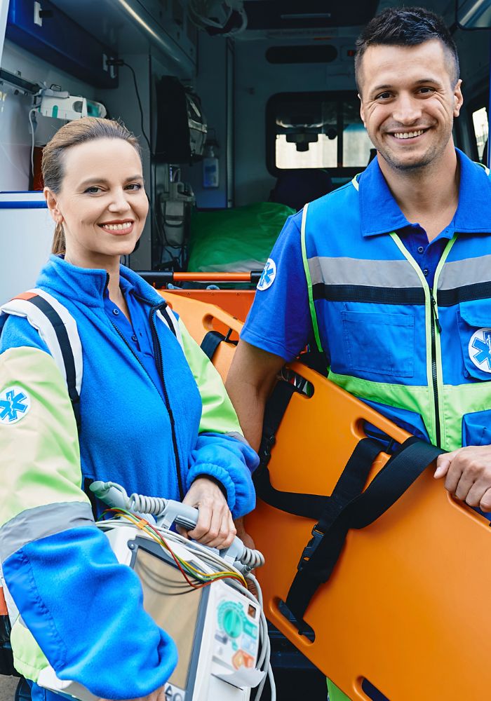 A man and woman are standing in front of an orange raft.