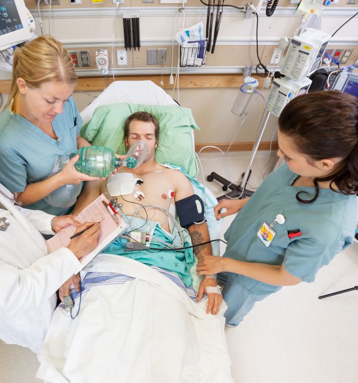 A man lying in a hospital bed with a tube in his mouth.