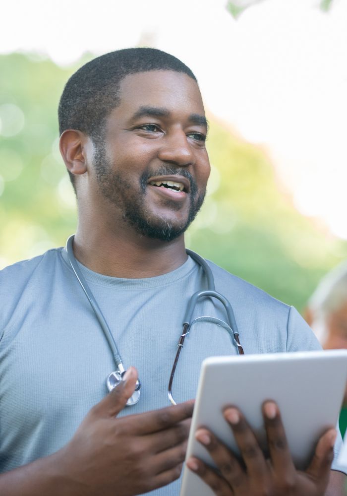 A man holding a notebook with a stethoscope around his neck.