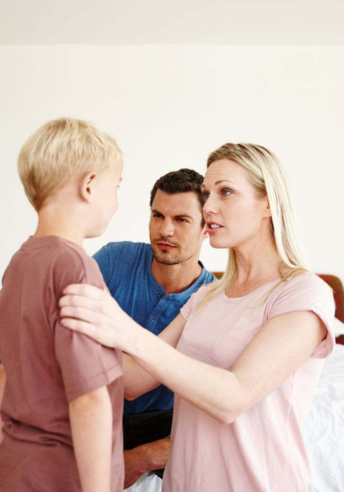 A woman in a pink shirt is hugging a boy.