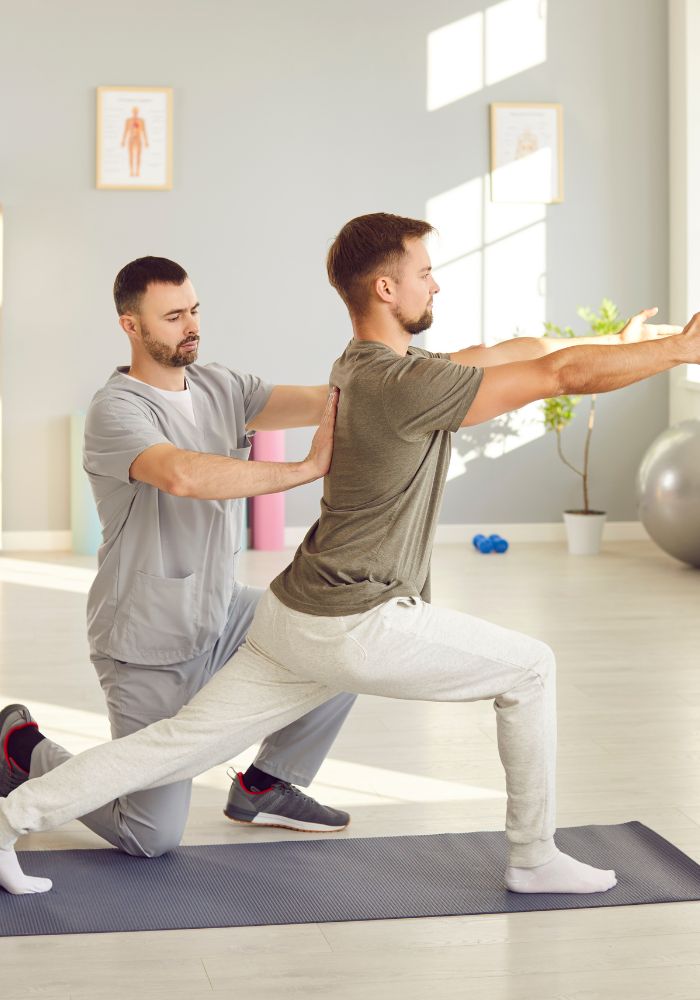 A man in a grey shirt and pants doing yoga.