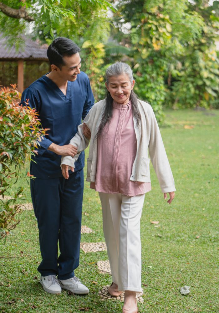 A man and woman walking together in a garden.
