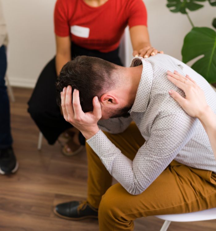 A man with a headache sitting in a chair.