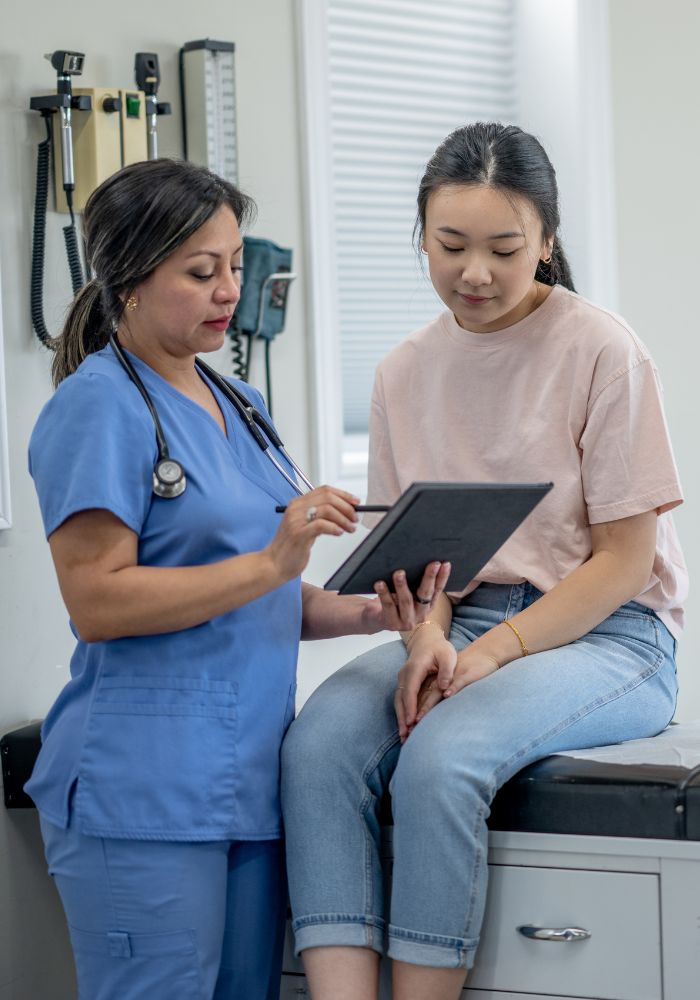 A woman in a blue shirt is showing a results to a girl.