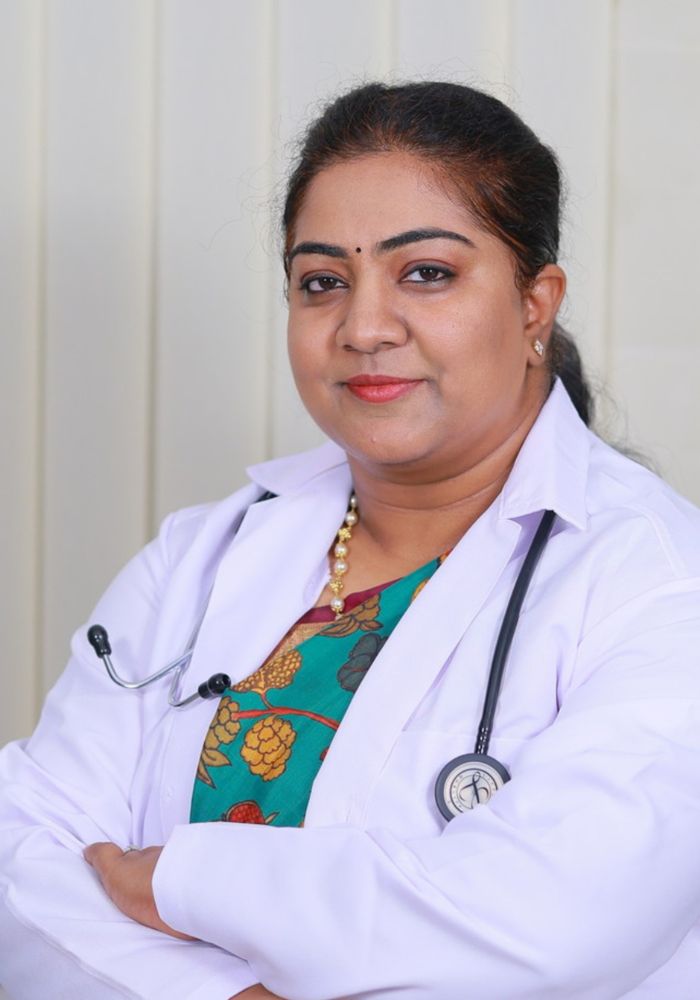 A woman wearing a white coat and a necklace.