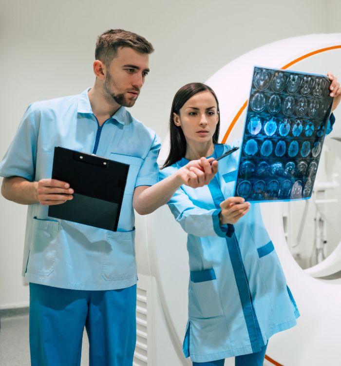 A man and woman are standing in front of a medical machine.