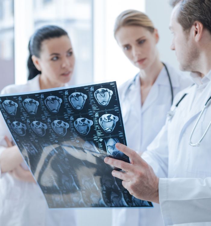 A man holding a medical chart with three women looking at it.