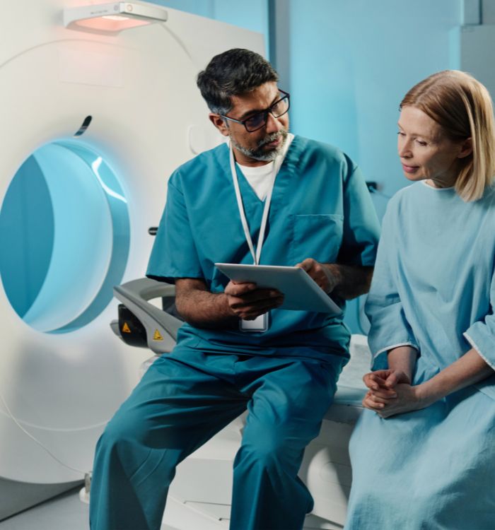 A man in a green shirt is looking at a chart with his patient.