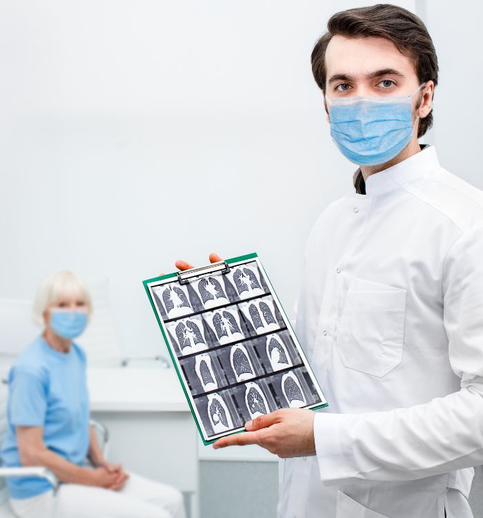 A man holding a medical chart with a woman in a blue shirt.