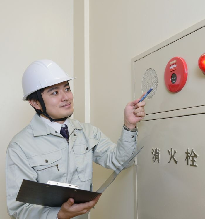 A man wearing a white helmet is holding a clipboard.