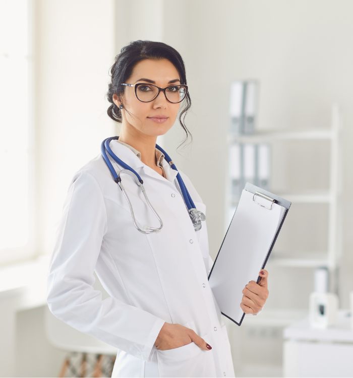 A woman in a white lab coat holding a clipboard.