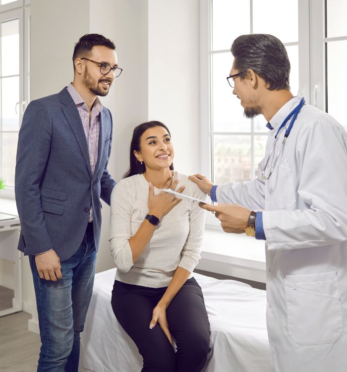 A man in a suit is showing a woman a thermometer.