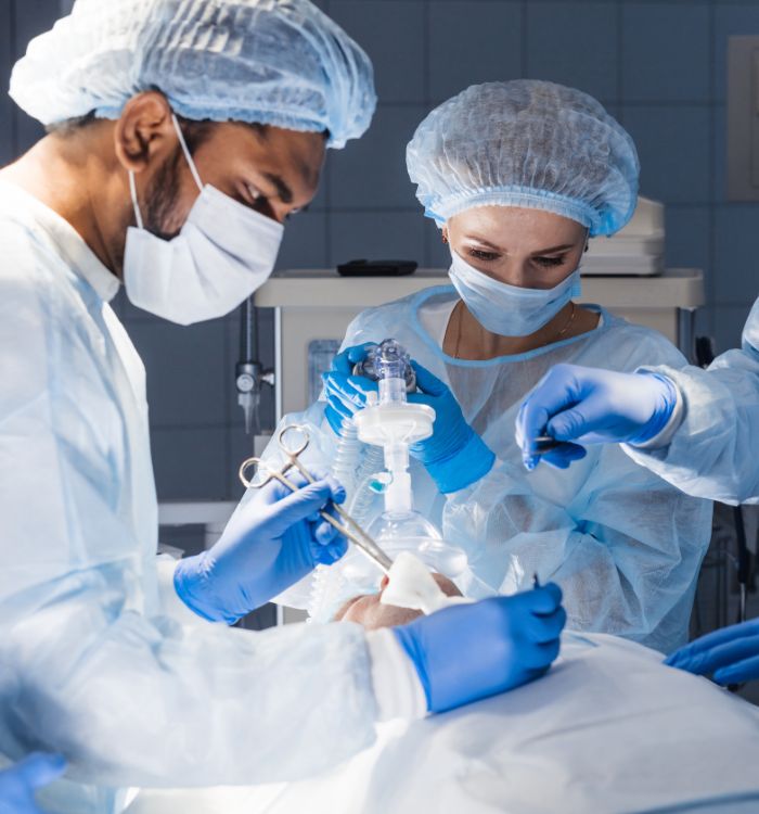 A man in a white lab coat is working on a patient.