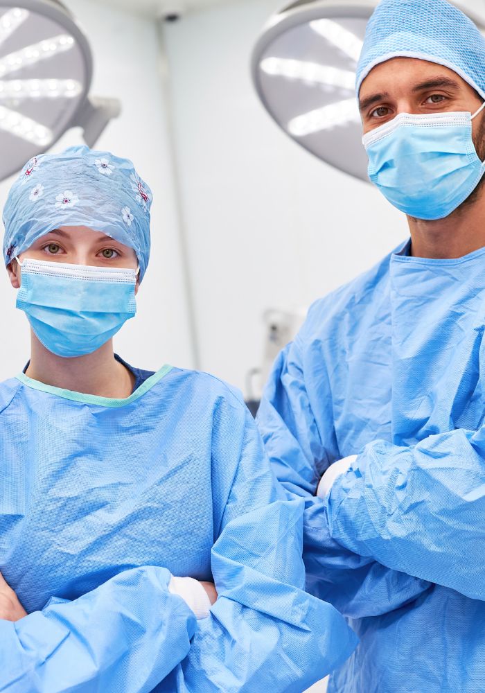 A man and woman wearing blue scrubs are standing together.
