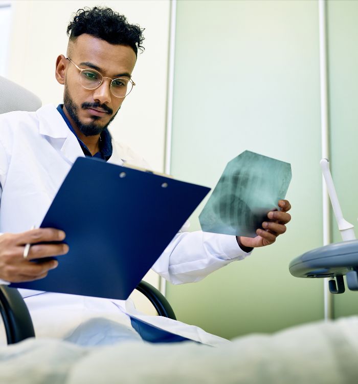 A man wearing glasses is reading a medical report.