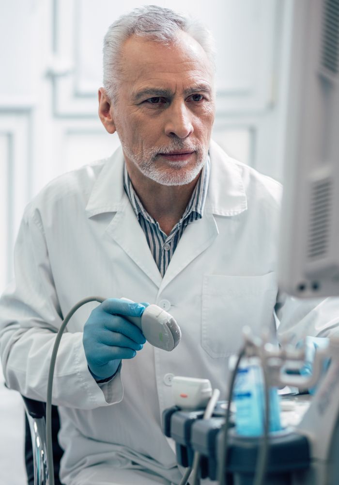 A man in a lab coat holding a device.
