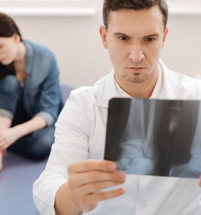 A man holding a black and white photo of a broken arm.