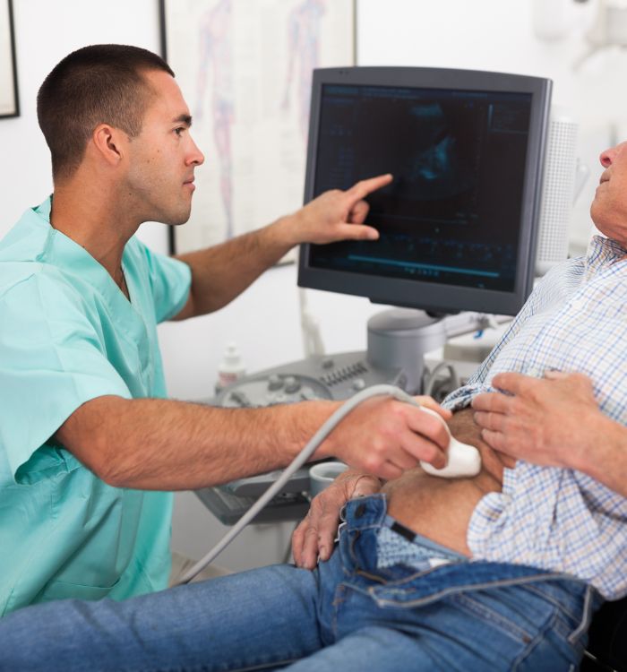 A man is laying on a table with a medical device on his stomach.