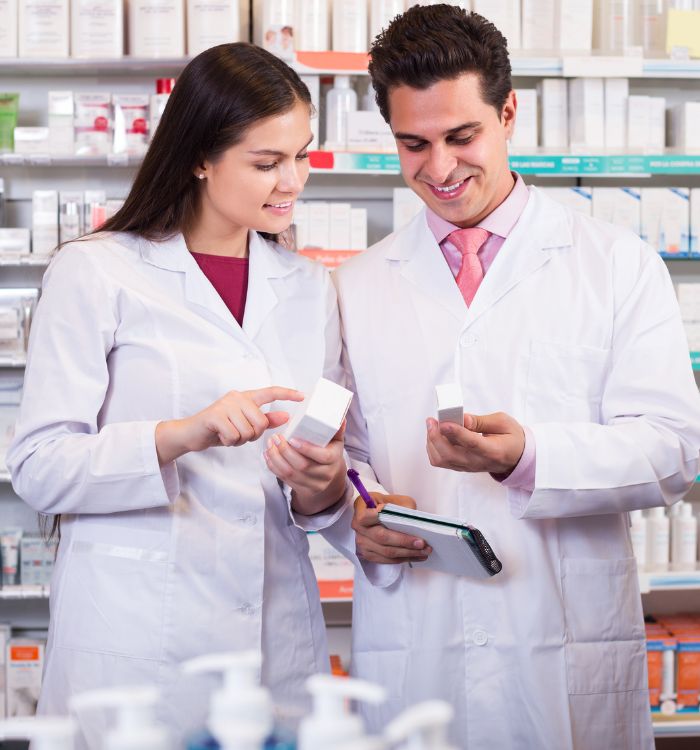 Two people in lab coats looking at a box.
