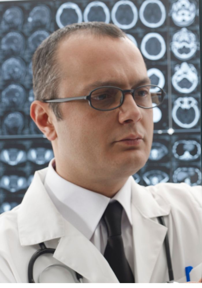 A man wearing glasses and a white lab coat.