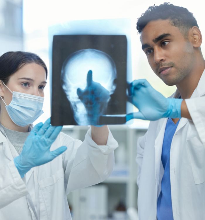 A man and woman are holding a picture of a skull.
