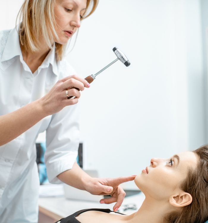 A woman getting examined by a woman in a white shirt.