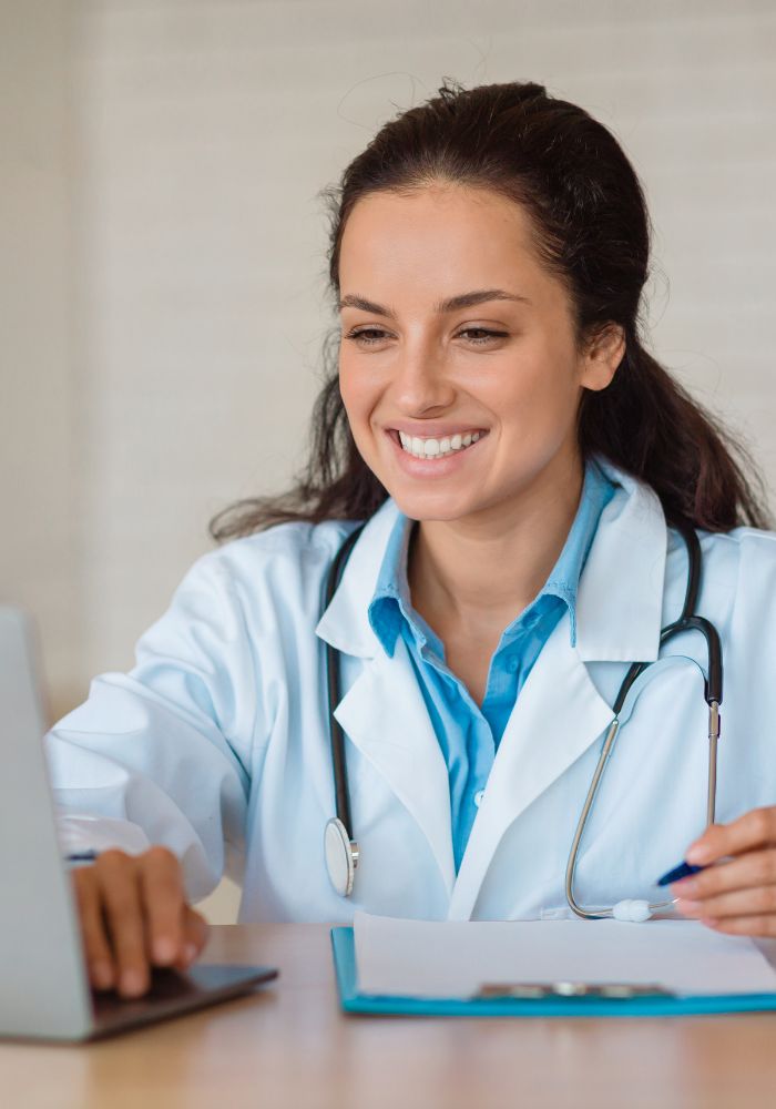 A woman in a white coat smiling at the camera.