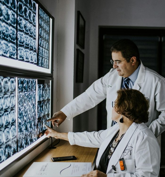 Two doctors looking at a screen with a lot of images on it.