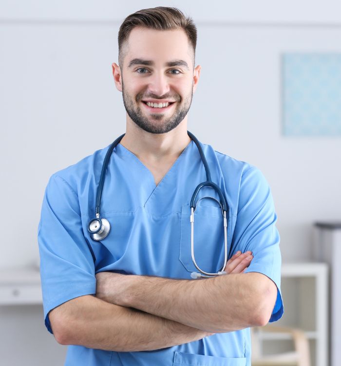 A man wearing a blue shirt and a white coat with a stethoscope around his neck.