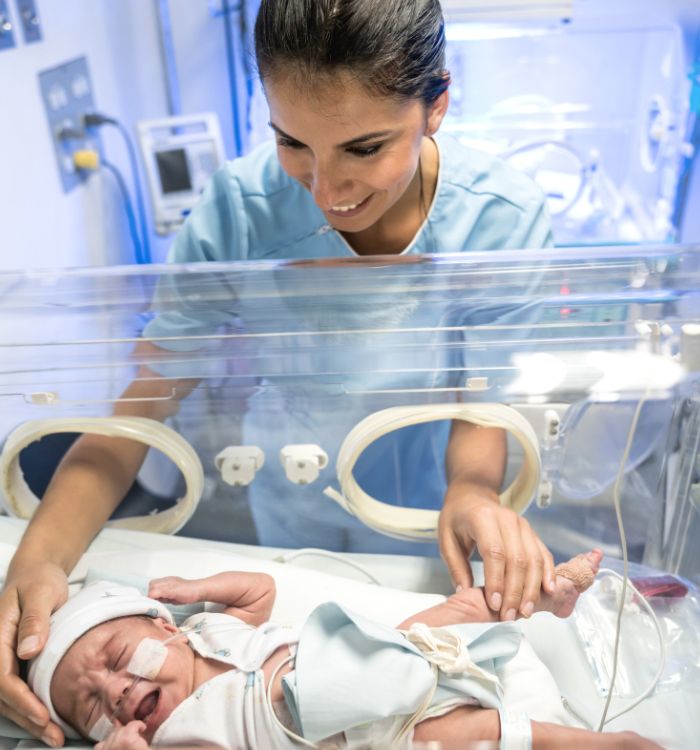A woman holding a baby in a hospital.