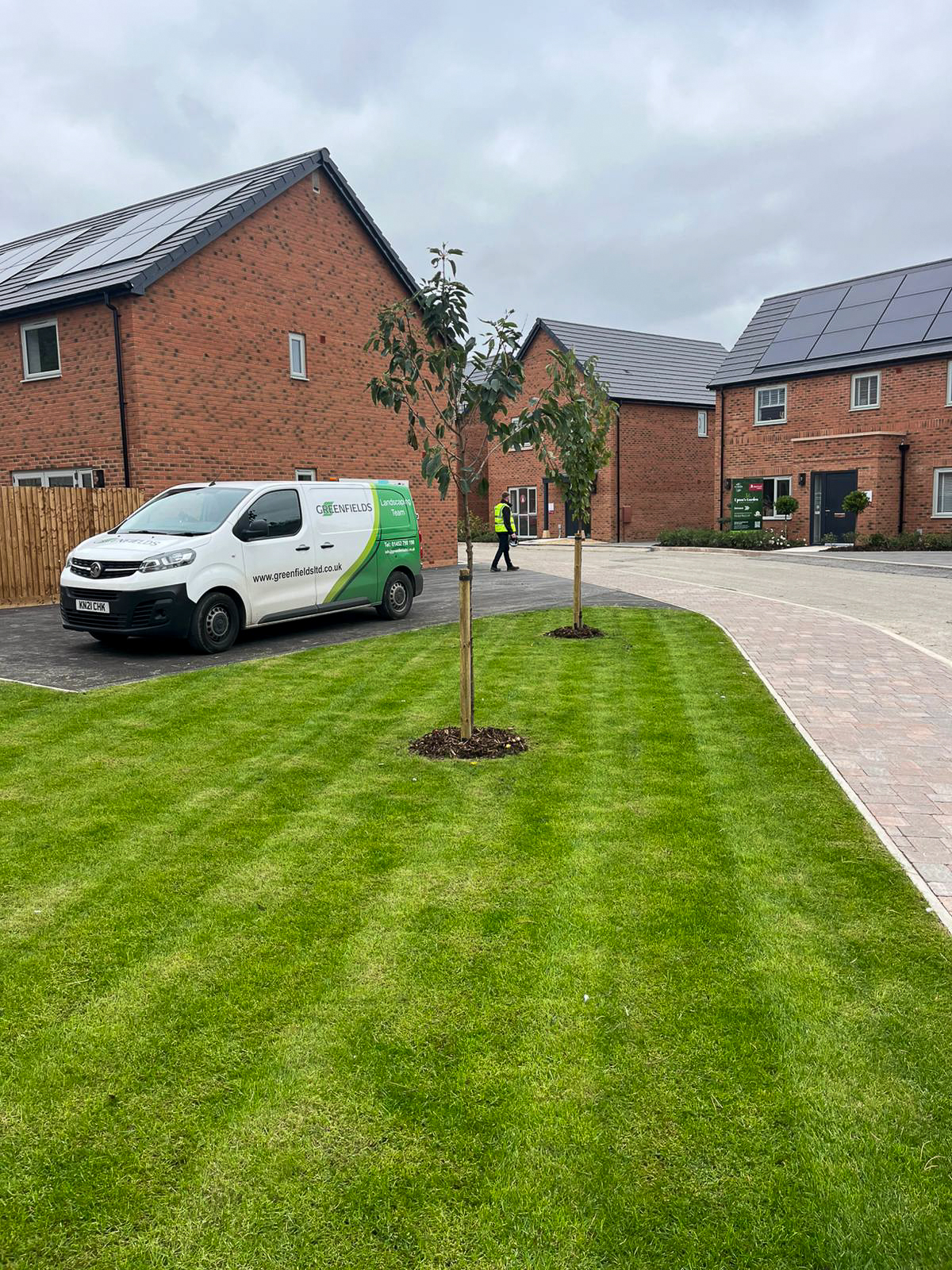 Young trees planted on a freshly turfed green beside the Greenfields landscaping van at Upton's Garden, Whitminster