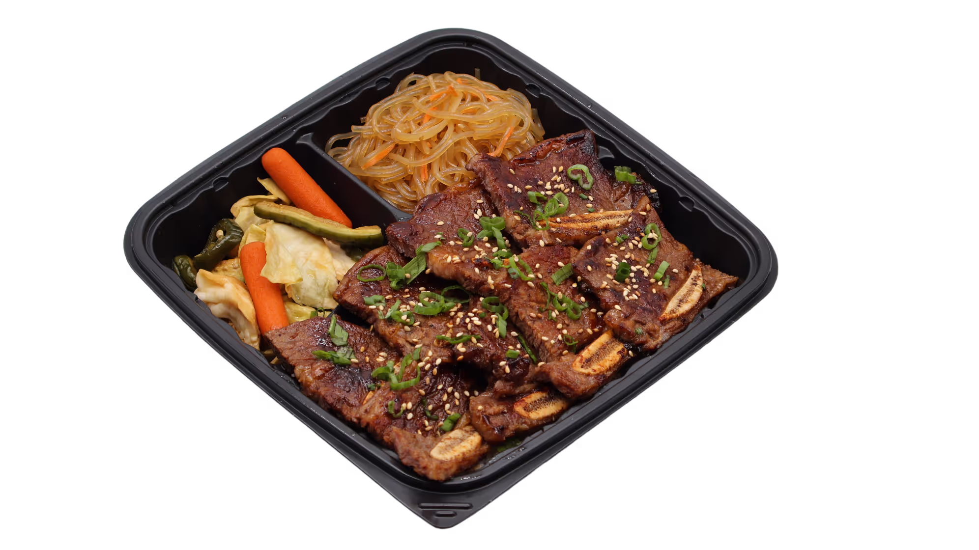 Grilled beef short ribs garnished with sesame seeds and green onions with noodles and vegetables in a black tray.