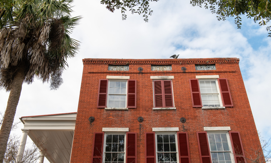 A building with red shuttersAI-generated content may be incorrect.