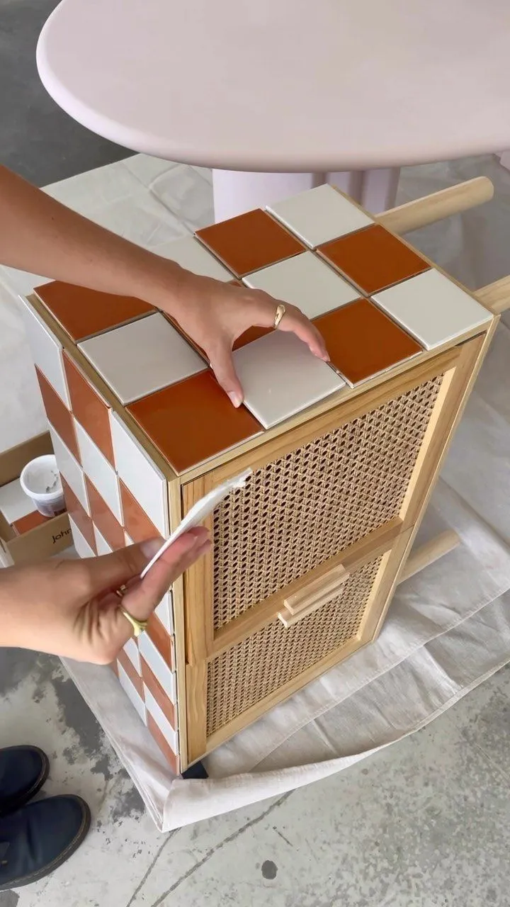 This may contain: a person standing next to a table with a white and brown checkered design on it