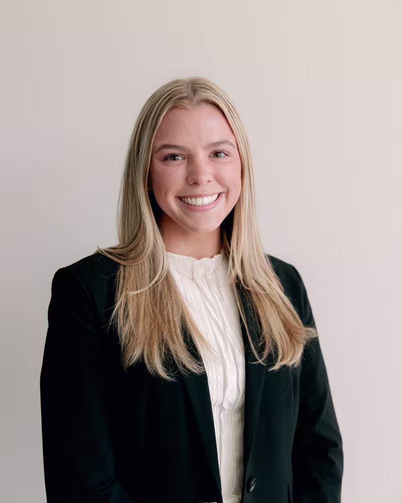 Professional portrait of a smiling blonde woman in a black blazer against a neutral background for Maven Financial Partners.