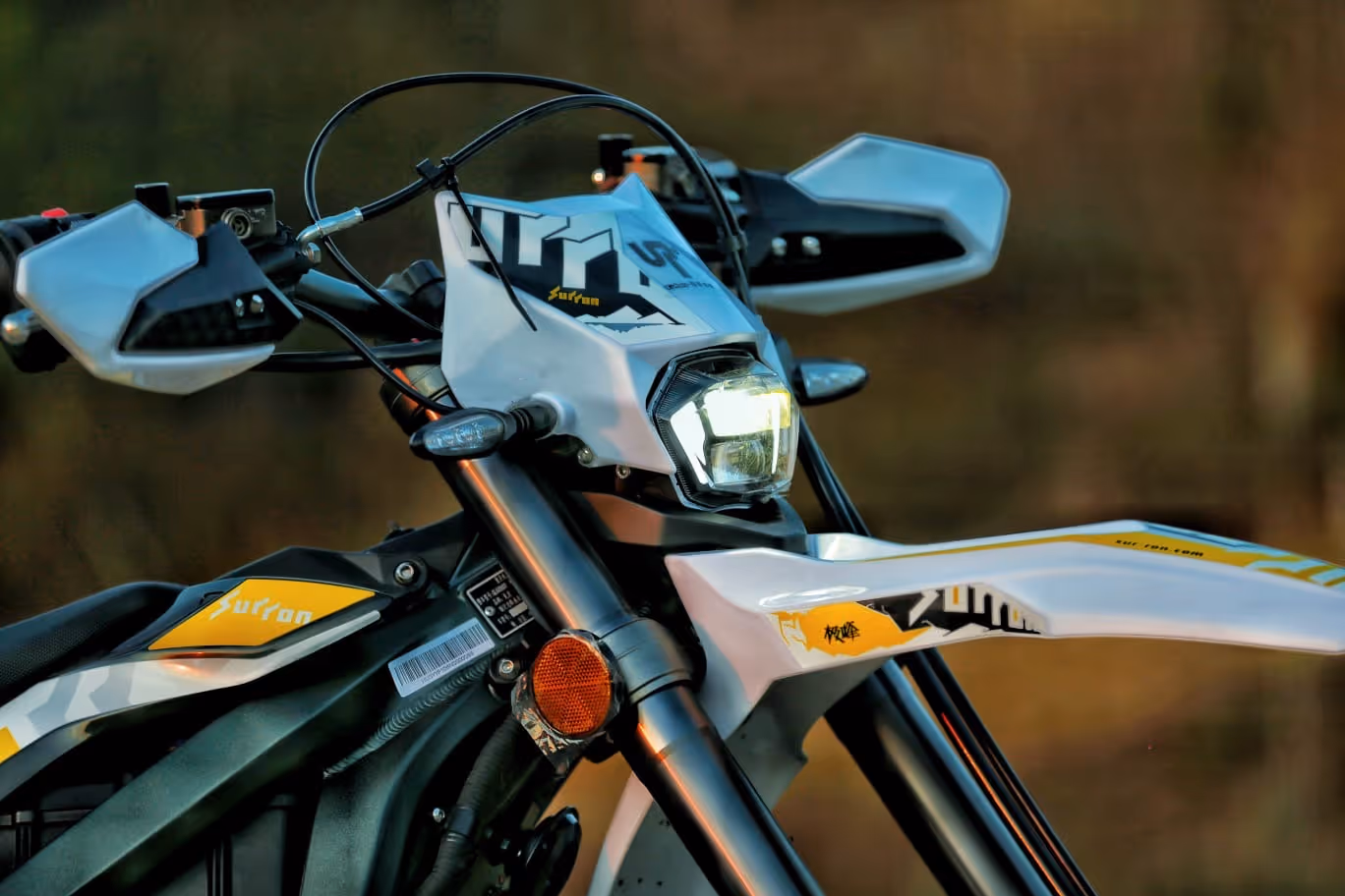 Front view of a white and yellow motorcycle with its headlight and handlebars visible.