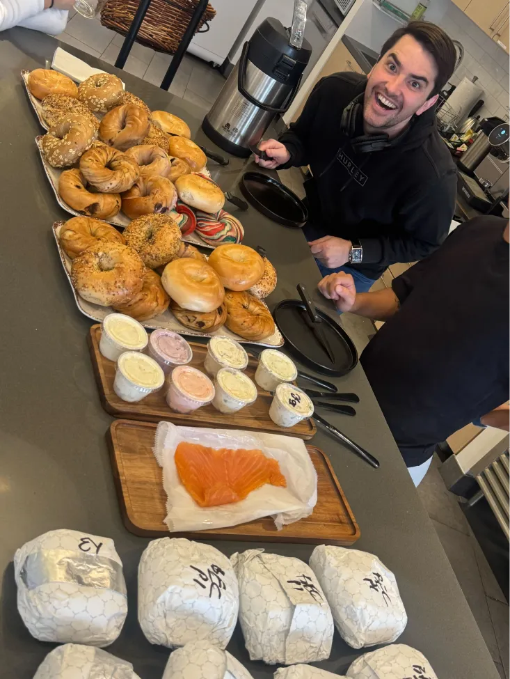 a man smiling in front of a platter of pastries