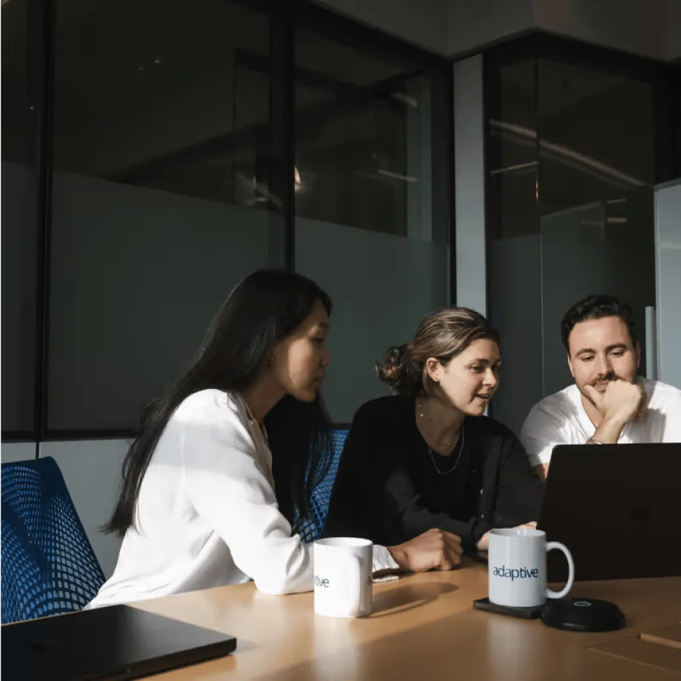 people sitting drinking coffee in front of a computer in an office environment